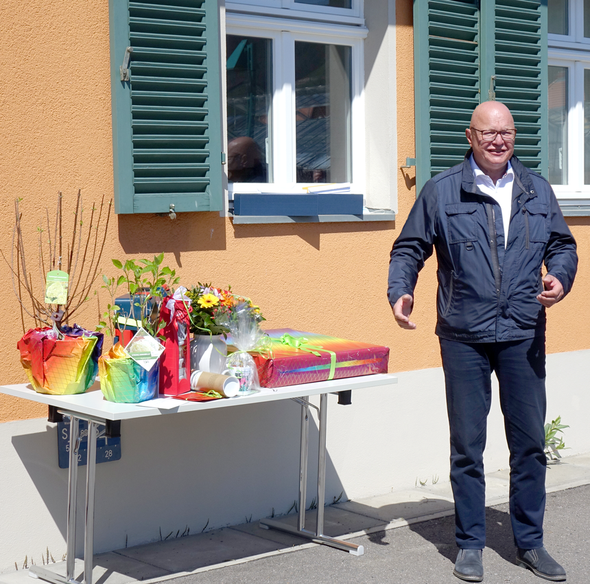 Herr Dr. Wackwitz vor einem Tisch mit Blumen und Geschenken.