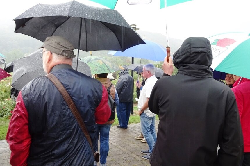 Besucher des Pillnitzer Versuchsfelds beim Rosentag mit Schirmen