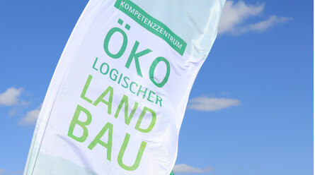 Fahne des Kompetenzzentrum Ökolandbau vor blauem Himmel