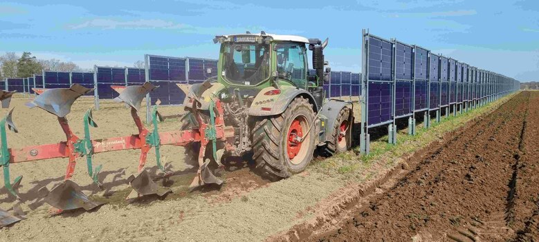 Pflug mit Traktor in Agri-PV-Anlage